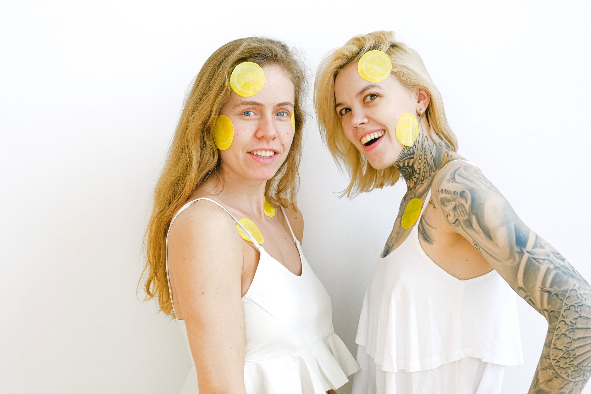 Yellow silicone vibrator surrounded by fresh lemons on a bright background