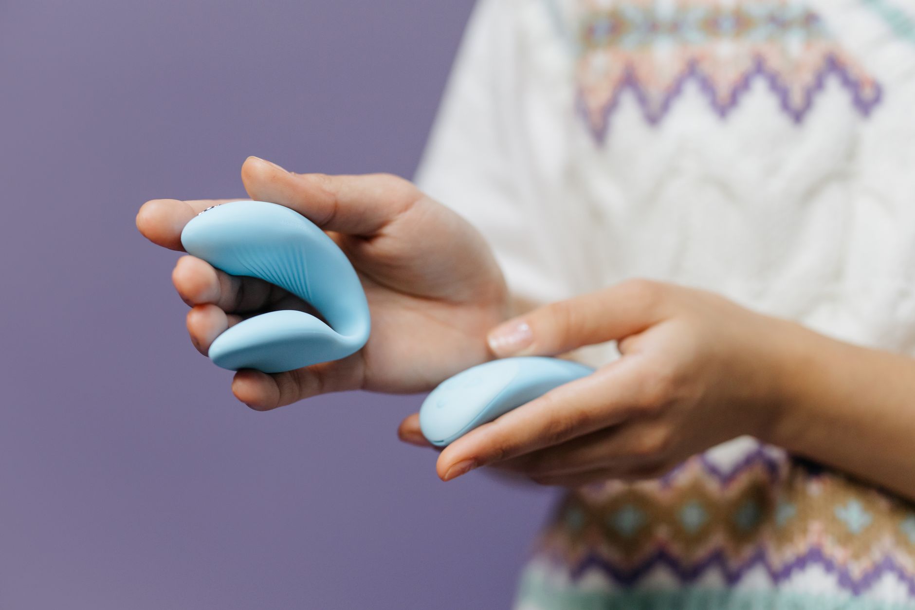 Close-up of hands holding a sleek vibrator, representing intimate communication and personal pleasure exploration.