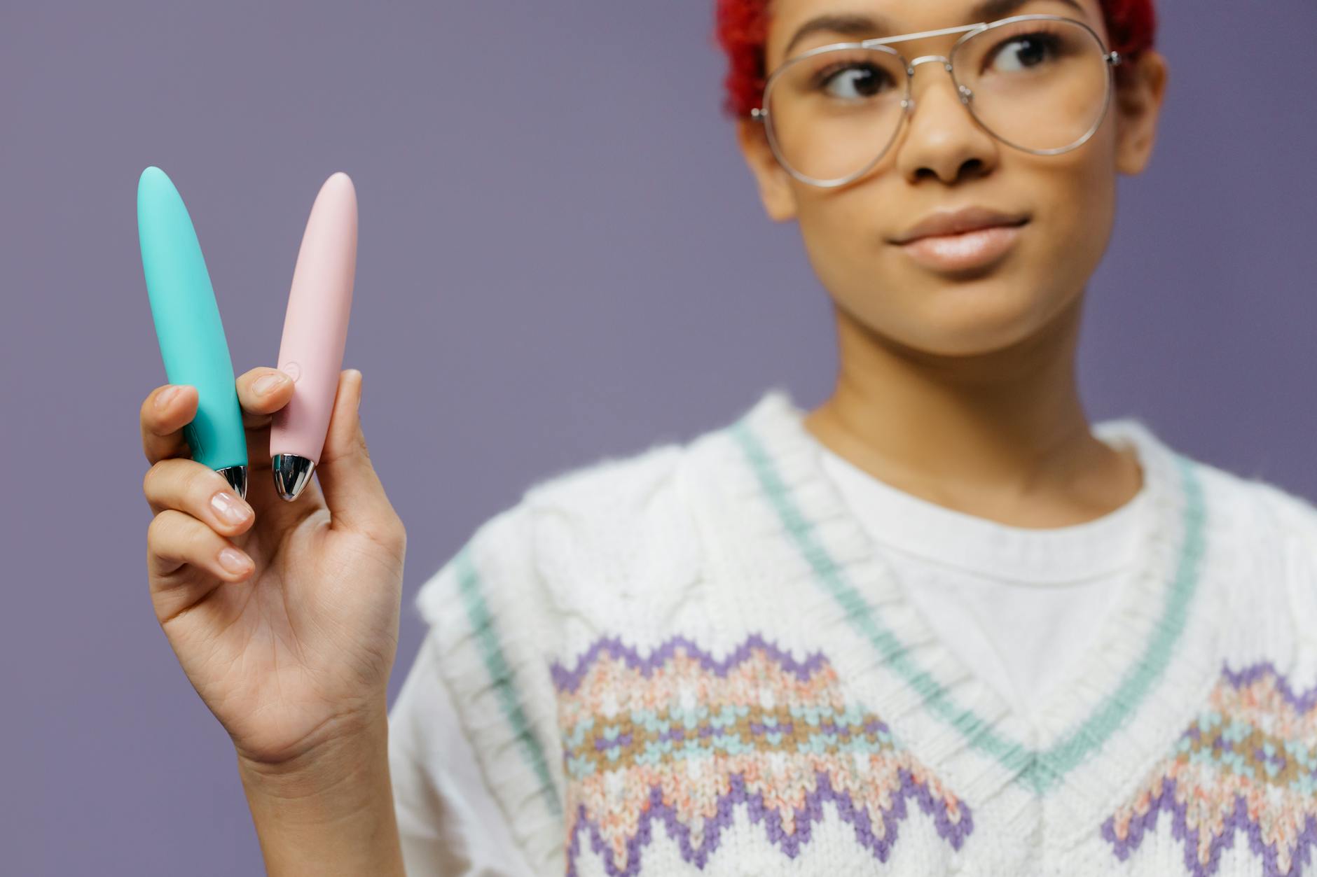 A person holding colorful vibrators, symbolizing gentle exploration and self-care without pressure