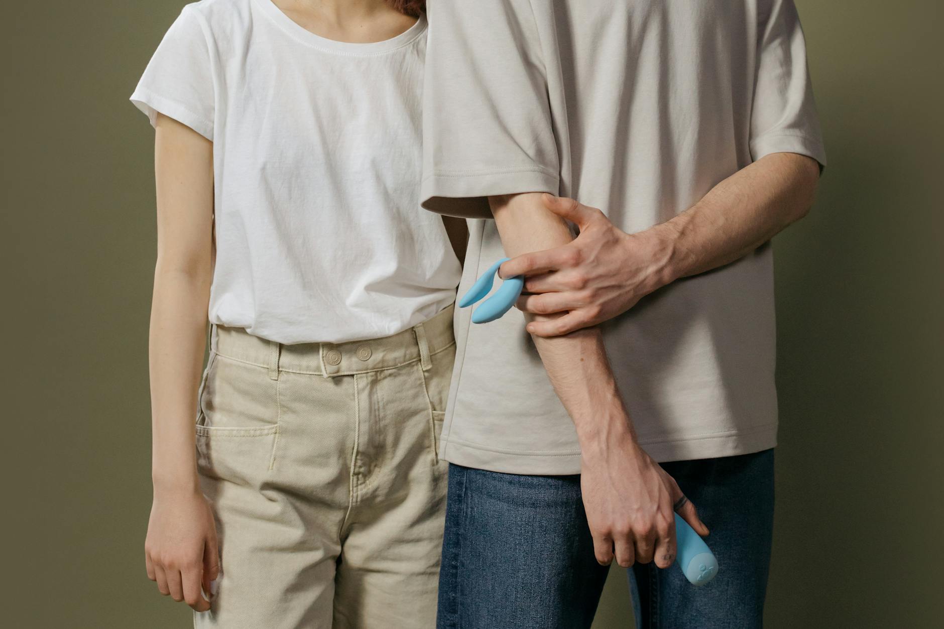 A couple holding a blue vibrator together, representing modern intimacy and reconnection