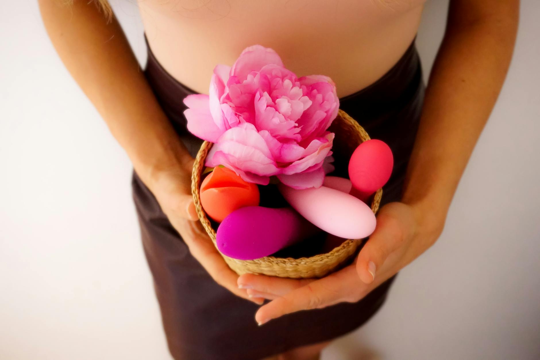 Close-up of hands holding a vibrator against a cozy knitted sweater
